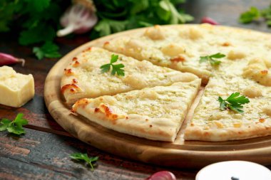 Tahtada otlarla sarımsaklı peynirli pizza..
