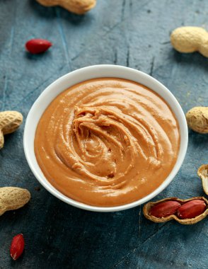 Smooth Peanut Butter in white bowl with nuts