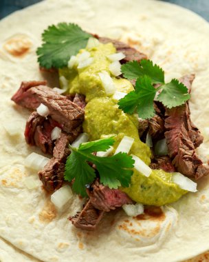 Izgara biftek, yeşil sos ve soğanlı Carne Asada Tacos. Meksika yemeği