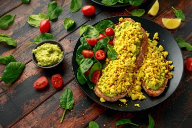 Çırpılmış soya peynirli tost, guacamole ve ıspanak, domates salatası. Vejetaryen vejetaryen, bitki temelli gıda