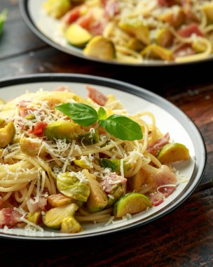 Ev yapımı Brüksel lahanası, pastırma, parmesan peynirli pancetta makarna. Tahta masada.