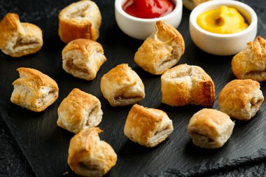 Köy taşında hardallı domuz sosisi ve ketçap.