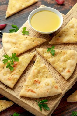 Tahtada taze sarımsaklı pizza ve şifalı otlar..