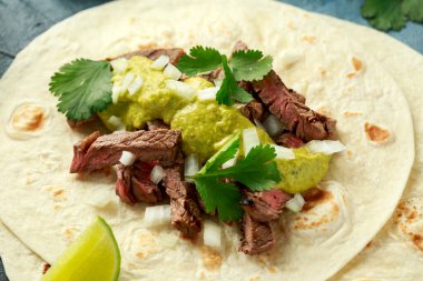 Izgara biftek, yeşil sos ve soğanlı Carne Asada Tacos. Meksika yemeği