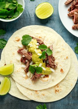 Izgara biftek, yeşil sos ve soğanlı Carne Asada Tacos. Meksika yemeği