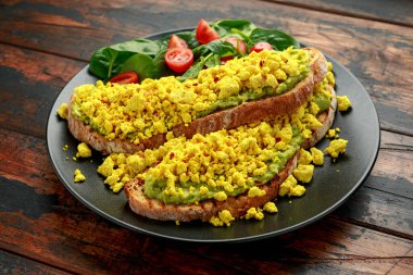 Çırpılmış soya peynirli tost, guacamole ve ıspanak, domates salatası. Vejetaryen vejetaryen, bitki temelli gıda