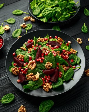 Taze ıspanaklı, nar tohumlu ve cevizli sağlıklı pancar salatası. sağlıklı vegan vejetaryen, bitki bazlı gıda
