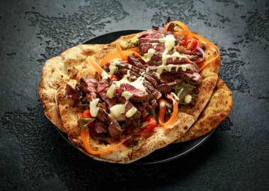 Izgara ve dilimlenmiş biftek sarımsaklı ve kişniş ekmekli havuçlu ve ev yapımı mayonez soslu ıspanak salatası.