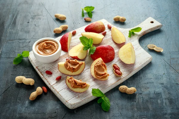 Peanut butter and apple to snack. on white wooden board