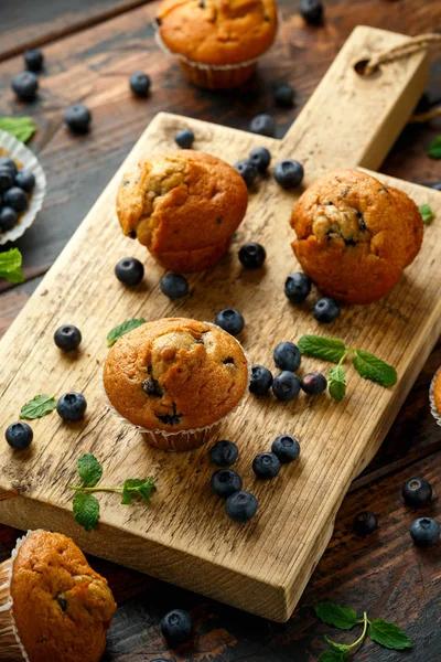 Bosbessen muffins, cupcake met munt en bes op houten plank. — Stockfoto