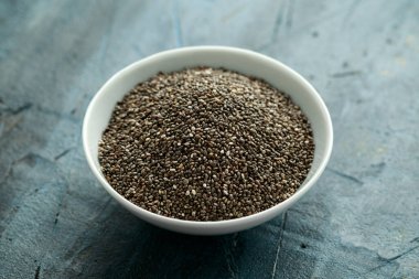 Beyaz kasede organik siyah Chia tohumları. Sağlıklı süper yiyecekler.
