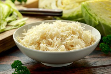 Fresh pickled cabbage in white bowl on wooden table. healthy food