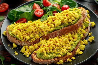 Çırpılmış soya peynirli tost, guacamole ve ıspanak, domates salatası. Vejetaryen vejetaryen, bitki temelli gıda
