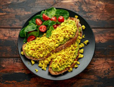 Çırpılmış soya peynirli tost, guacamole ve ıspanak, domates salatası. Vejetaryen vejetaryen, bitki temelli gıda