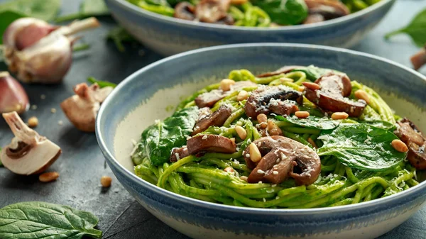 Vegansk vitlökspasta med spenat och avokadopesto, dränkt i sesamfrön och rostade pinjenötter — Stockfoto