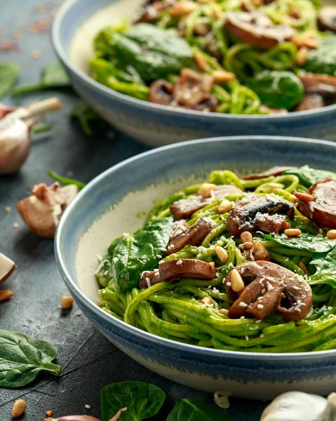Vegansk vitlökspasta med spenat och avokadopesto, dränkt i sesamfrön och rostade pinjenötter — Stockfoto
