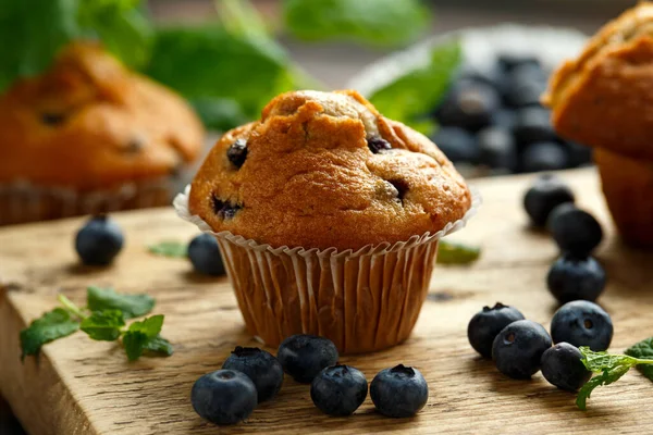 Blueberries muffins, cupcake with mint and berry on wooden board. — Stock Photo, Image
