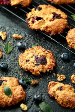 Ev yapımı yabanmersini ve siyah arka planda cevizli kurabiye.