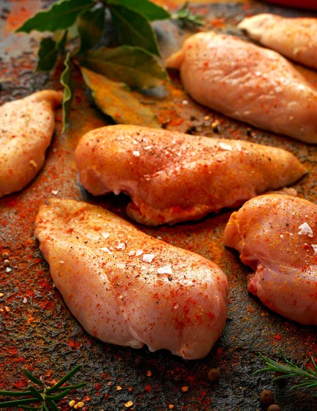 Filetes de pechuga de pollo crudos listos para cocinar sazonados con pimentón, pimienta rajada y copos de sal marina — Foto de Stock
