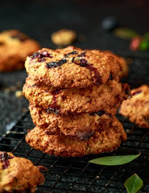 Ev yapımı yabanmersini ve siyah arka planda cevizli kurabiye.