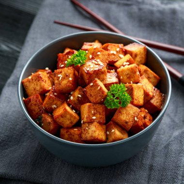 Çubuk ve susamlı kase içinde kızarmış tofu.