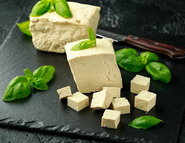 Organiczne Tofu sojowe z bazylią na ciemnej rustykalnej tablicy kamiennej — Zdjęcie stockowe