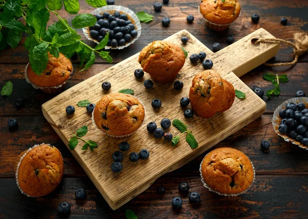 Bosbessen muffins, cupcake met munt en bes op houten plank. — Stockfoto