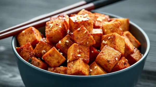 Tofu frito en un tazón con palillo y semillas de sésamo — Foto de Stock