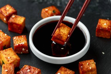 Kızarmış tofu, çubuk ve susam tohumları.