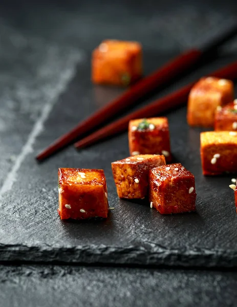 Gebratener Tofu mit Essstäbchen und Sesam auf rustikalem Steinbrett — Stockfoto