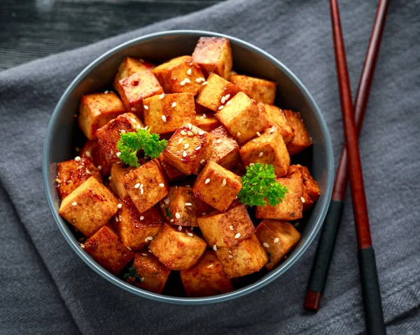 Çubuk ve susamlı kase içinde kızarmış tofu.