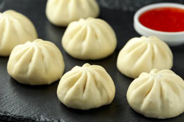 Ördek dolması ile buharda pişmiş çörekler, taşrada kırmızı biber sosu. Asya yemekleri