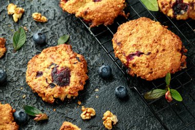 Ev yapımı yabanmersini ve siyah arka planda cevizli kurabiye.