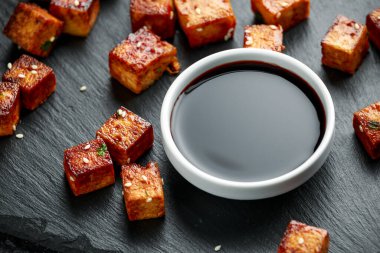 Kızarmış tofu, çubuk ve susam tohumları.