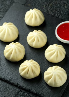 Ördek dolması ile buharda pişmiş çörekler, taşrada kırmızı biber sosu. Asya yemekleri