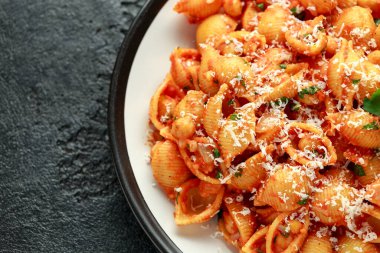 Domates soslu nohut ve parmesan peynirli Conchiglie rigate makarnası. Sağlıklı vejetaryen yemekleri.