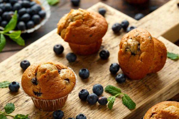 Jagodowe muffinki, babeczka z miętą i jagodami na drewnianej desce. — Zdjęcie stockowe