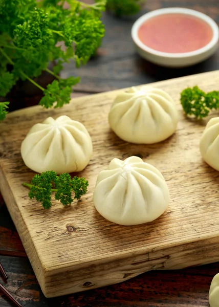 Bollos al vapor con relleno de pato, salsa de chile sobre tabla de madera. Comida asiática . —  Fotos de Stock