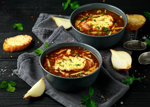 French onion soup with cheese toast on rustic background