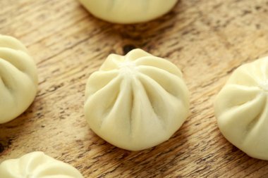 Ördek dolması ile buharda pişmiş çörek, ahşap tahtada kırmızı biber sosu. Asya yemekleri.