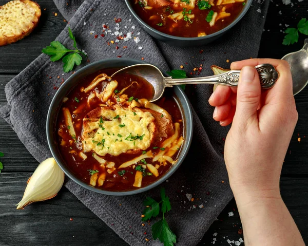 French onion soup with cheese toast on rustic background