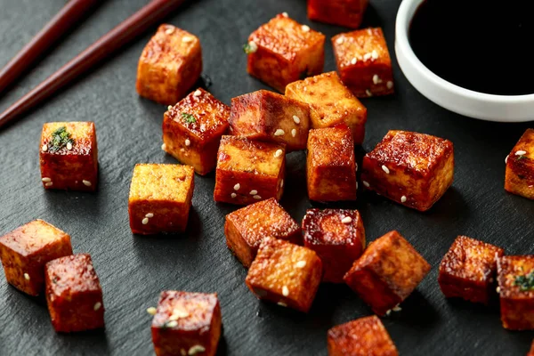Tofu frito con palillo y semillas de sésamo sobre tabla de piedra rústica — Foto de Stock