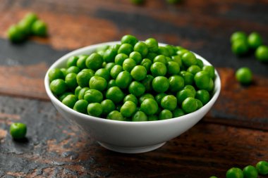 Beyaz kasede yeşil bezelyeler. Sağlıklı yemek.