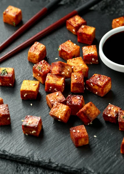 Tofu frito con palillo y semillas de sésamo sobre tabla de piedra rústica — Foto de Stock