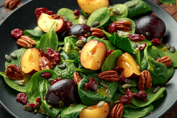 Ensalada de ciruelas veganas con arándano, semillas de calabaza, nueces de pacanas, espinacas y aderezo de mostaza — Foto de Stock