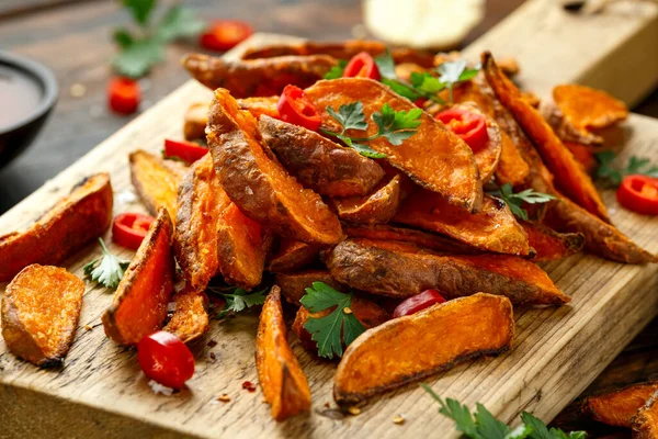 Cunhas de batata-doce de laranja cozida no forno saudável com molho de mergulho, ervas, sal e pimenta no tabuleiro de madeira — Fotografia de Stock