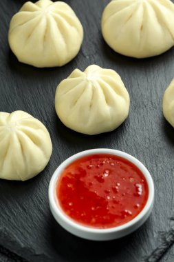 Ördek dolması ile buharda pişmiş çörekler, taşrada kırmızı biber sosu. Asya yemekleri.