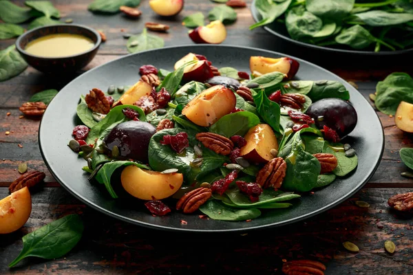 Салат зі сливами Веган з журавлиною, гарбузовим насінням, горіхами пеганів, шпинатом та гірчицею — стокове фото