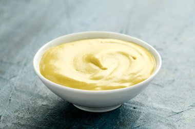 Dijon hardalı beyaz kasede, kırsal arka planda.