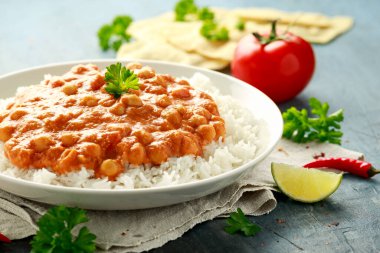 Acılı nohut körisi, pilav, domates ve beyaz tabakta Poppadom. Sağlıklı, lezzetli vejetaryen yemekleri.